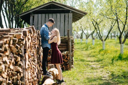 Cute couple in a park. Lady in a red dress. Boy in a blue shirt