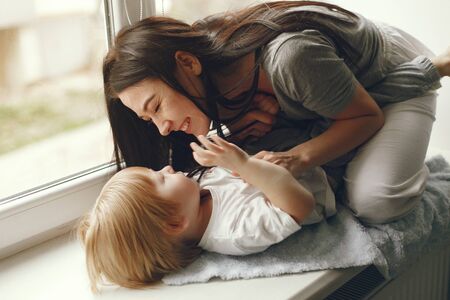 Mother and little son sitting on a windowsillの写真素材