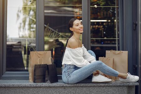 Elegant and stylish girls in a summer city with shopping bagsの写真素材