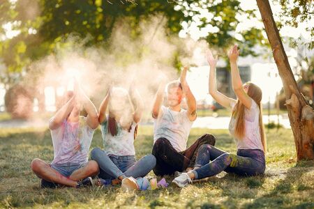 Friends with a holi paints. People in a summer park. Students have fun.の写真素材