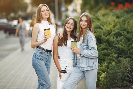 Girls walking in a spring sity and hold coffee in her handの写真素材