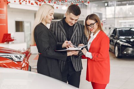 Stylish and elegant people in a car salonの写真素材