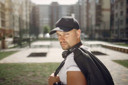Handsome man standing in a park with a headphonesの写真素材