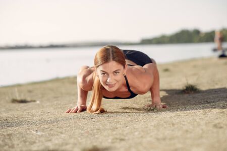 Beautiful woman training by the waterの写真素材