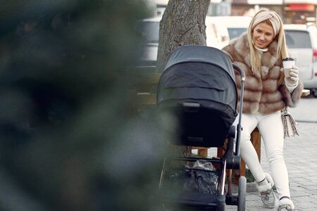 Stylish woman sitting in a city with carriage