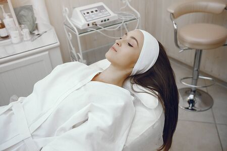 Woman in a white bathrobe in a cosmetology studioの写真素材