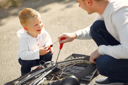 Father with son repare the bike in a parkの写真素材