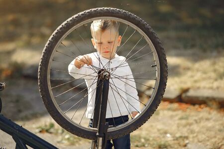 Little boy repair his bike in a parkの写真素材