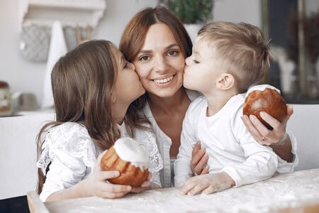 Family sitting in a kitchen and cook the dough for cakeの写真素材