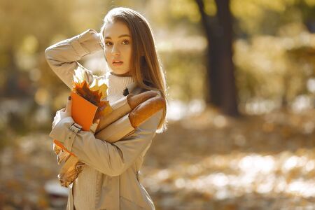 Elegant and stylish girl in a autumn parkの写真素材