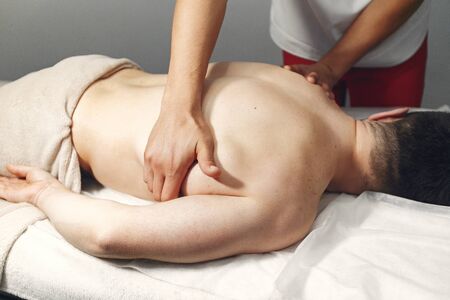 The doctor massages the man in the hospitalの写真素材