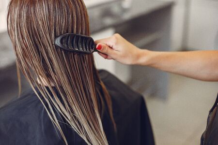 Hairdresser drying head her client. Woman in a hair salonの写真素材