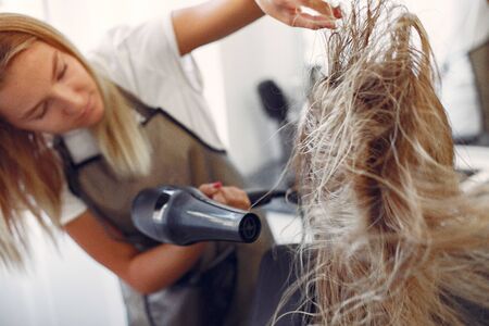 Woman drying hair in a hairsalonの写真素材