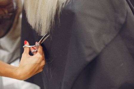 Hairdresser cut hair her client. Woman in a hair salonの写真素材