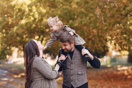 Family with little daughter in a autumn parkの写真素材