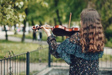 Girl in a summer park. Lady with a violin. Girl in a summer dress