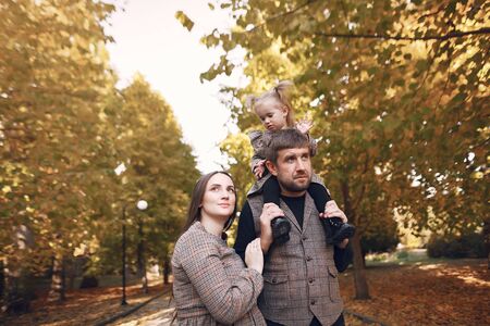 Family with little daughter in a autumn parkの写真素材