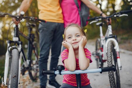 Family with a bicycle in a summer parkの写真素材