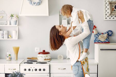 Cute little son with mother. Family at home in a kitchen.の写真素材