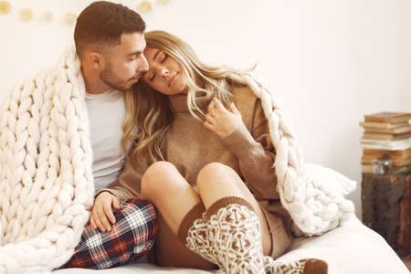 Couple sitting on a bed in a room