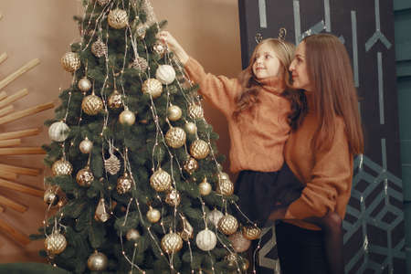 Mother with cute daughter near christmas treeの写真素材