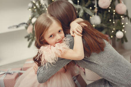 Mother with cute daughter near christmas treeの写真素材