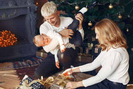 Family with little son at home near christmas tree