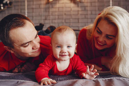 Family sitting at home on a bed