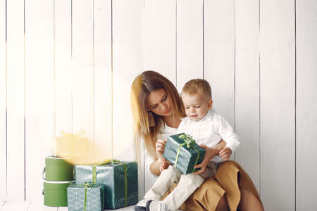 Elegant mother sitting at home with little sonの写真素材