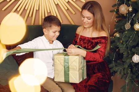 Elegant mother sitting at home with little sonの写真素材