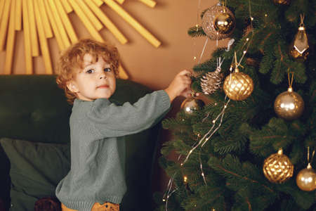 Little boy near christmas tree in a gray sweaterの写真素材