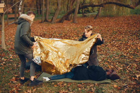 Two boys in a autumn park help a african girlの写真素材