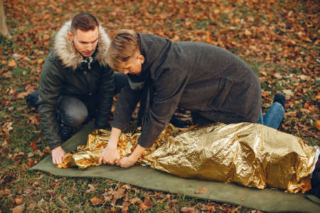 Two boys in a autumn park help a african girlの写真素材