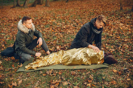 Two boys in a autumn park help a african girlの写真素材