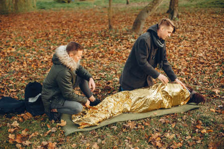 Two boys in a autumn park help a african girlの写真素材