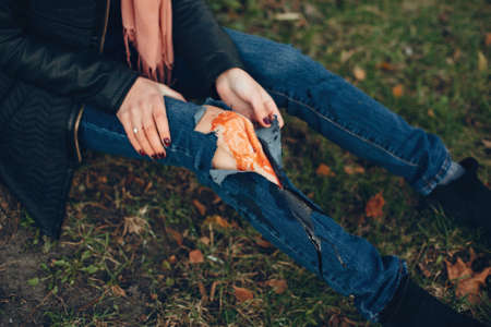 Girl with a broken leg in the autumn park