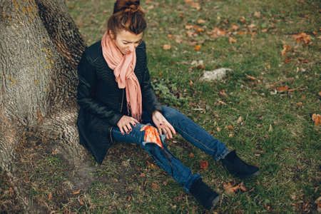 Girl with a broken leg in the autumn park