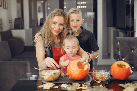 Family cuts pumpkins in the kitchenの写真素材