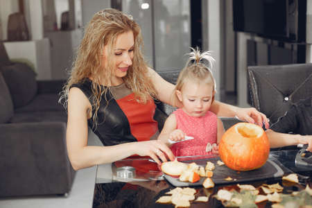 Family cuts pumpkins in the kitchenの写真素材