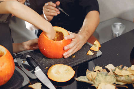 Family cuts pumpkins in the kitchenの写真素材