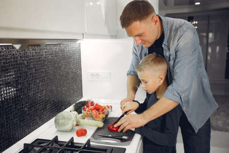 Beautiful family prepare food in a kitchenの写真素材