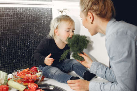 Beautiful family prepare food in a kitchenの写真素材