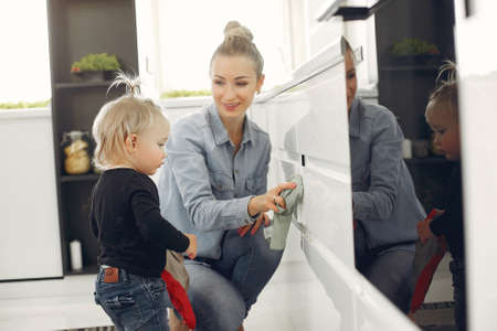 Mom and daughter clean up in the kitchenの写真素材