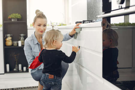 Mom and daughter clean up in the kitchenの写真素材