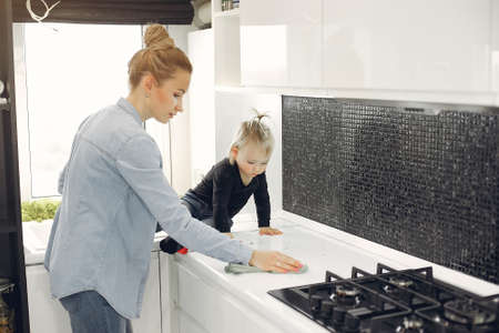 Mom and daughter clean up in the kitchenの写真素材