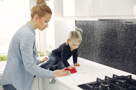 Mom and daughter clean up in the kitchenの写真素材