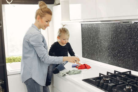 Mom and daughter clean up in the kitchenの写真素材