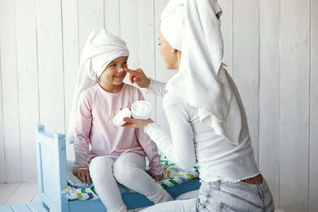 Mom playing with cosmetics with her daughterの写真素材