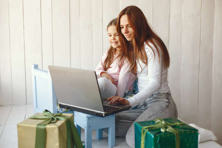 Woman with daughter using laptop computerの写真素材