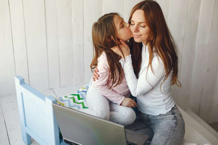 Woman with daughter using laptop computerの写真素材